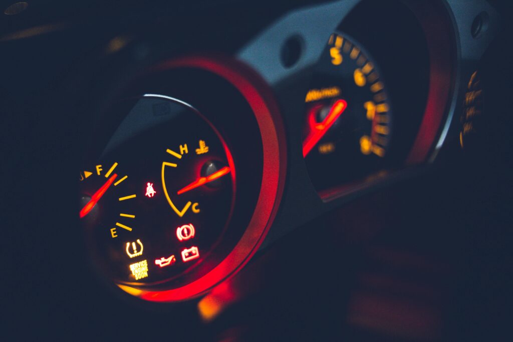 Driver’s hands on the steering wheel with a view of the car’s dashboard, highlighting good driving habits that can increase car battery life.